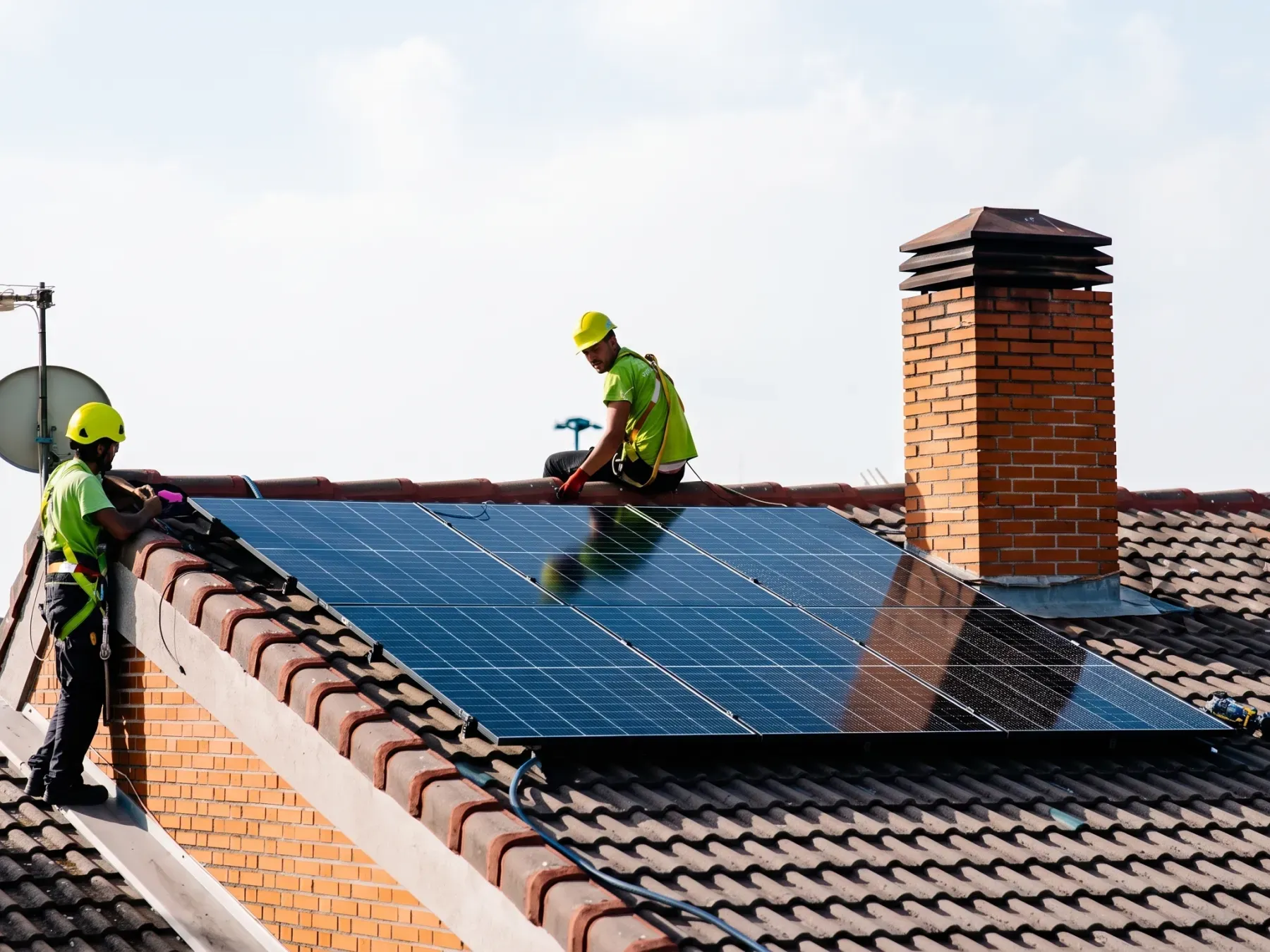 Profissionais instalando painéis solares em um telhado